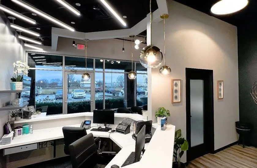 Front desk workstations with large windows and modern pendant lighting