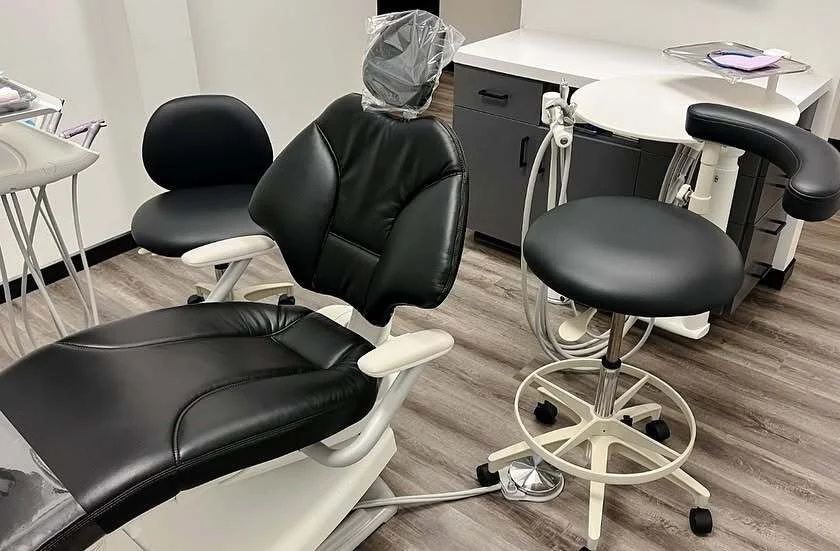 Comfortable dental chair and assistant stool in a treatment room